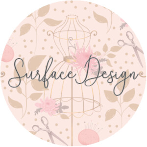 A circular graphic labeled "surface design" featuring a surrealism-inspired stylized mannequin, flowers, scissors, and leaves in a soft pink and beige color palette.