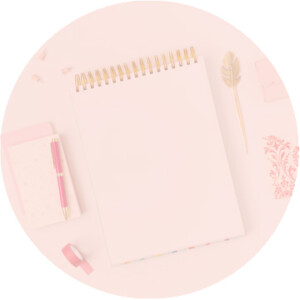 A flat lay of a blank notebook, a gold pen, a pink eraser, and a decorative leaf on a pale pink background, conveying a soft, organized workspace inspired by surrealism.