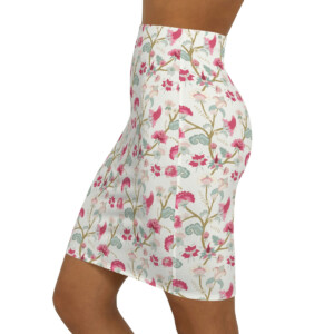 A side view of a woman wearing a whimsical floral print mini skirt, featuring a pattern of pink and green flowers with light blue accents, against a white background.