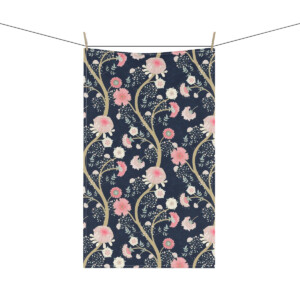 A whimsical, floral-patterned tapestry hanging on a clothesline, featuring pink and white flowers with green leaves on a dark navy background.
