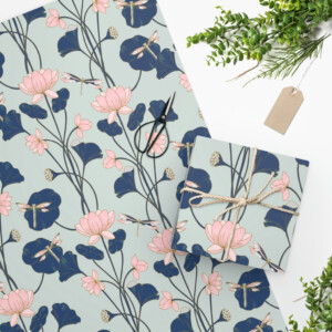 Gift wrapping paper with a whimsical floral pattern featuring blue and pink flowers, tied with a string and accompanied by greenery and a blank tag.