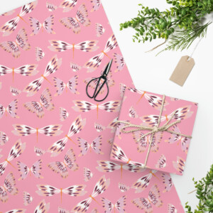 Top view of Flying Cuties in Pink Wrapping Paper with a whimsical white and brown butterfly pattern, featuring scissors, a gift box tied with twine, a tag, and green foliage on a white surface.