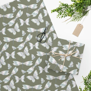 Sentence with Product Name: A neatly wrapped gift box with twine and scissors, displayed on a Custom Wrapping Paper with surreal butterfly motifs, alongside fresh green foliage and a blank tag.