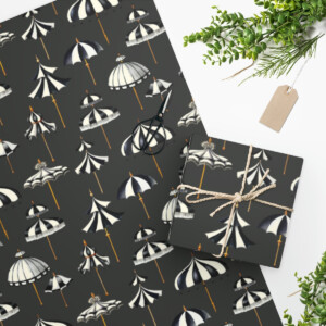 Flat lay of a notebook with whimsical black and white Victorian Umbrellas Custom Wrapping Paper pattern, tied with twine next to scissors and a plant, on a matching umbrella-patterned background.