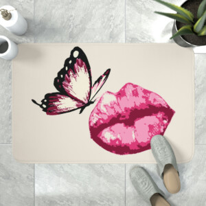 An artistic doormat featuring a large pink lipstick kiss print with a black and white butterfly perched on the edge, placed on a tiled floor with a pair of grey slippers nearby, exuding