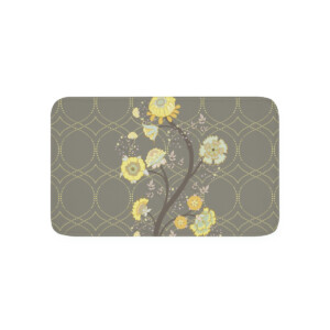 A doormat featuring a symmetrical gray geometric pattern background with a vertical line of assorted yellow and white flowers, exuding a surrealism-inspired elegance and inviting look.